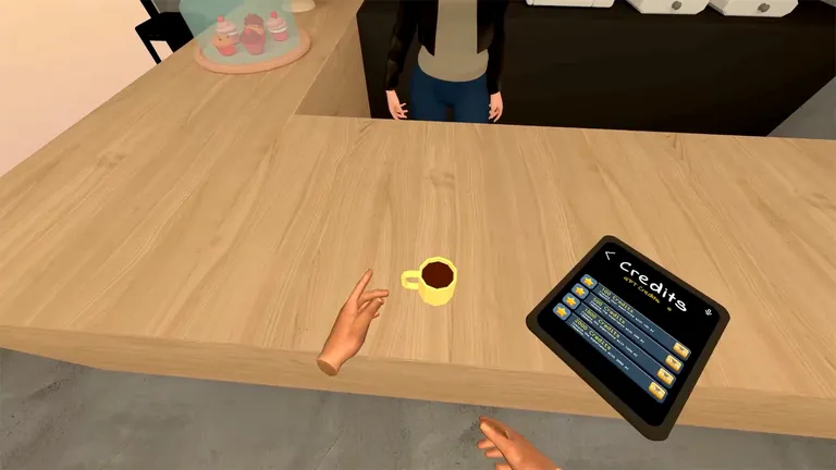 A cup of coffee on the wooden counter next to the credits tablet